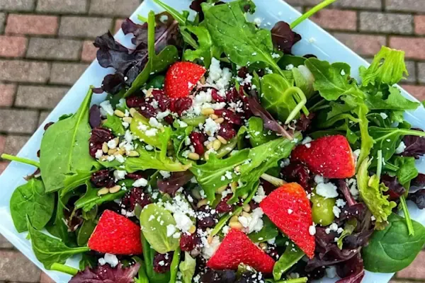 Spring mix, grapes, strawberries, pine nuts, dried cranberries, feta cheese, lemon honey dressing on the side