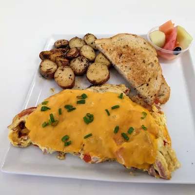 Eggs, grilled ham, grilled red onions, red bell peppers, yellow cheddar cheese with your choice of toast and your choice of side item (hash-browns, skillet potatoes or fruit)