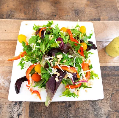 Spring mix, arugula, bell peppers, heirloom tomatoes, roasted corn, shredded jack cheese, pepita seeds, cilantro lime vinaigrette dressing on the side.