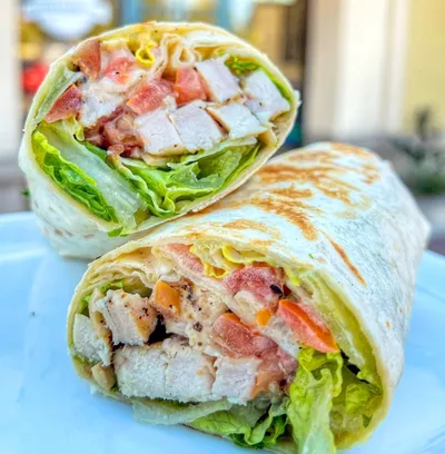 Flour tortilla, Caesar dressing, chicken breast, bacon, tomatoes, romaine lettuce, parmesan cheese, crushed croutons.