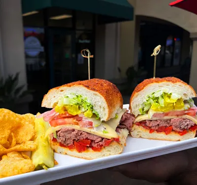 Roast beef, house peppercorn sauce, Havarti cheese, romaine lettuce, pickles, tomatoes, house roasted bell peppers, banana peppers, house pickled onions on a Dutch crunch roll